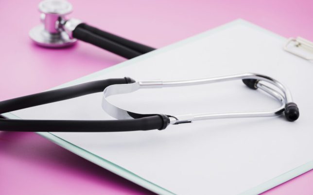 stethoscope-white-paper-clipboard-against-pink-background